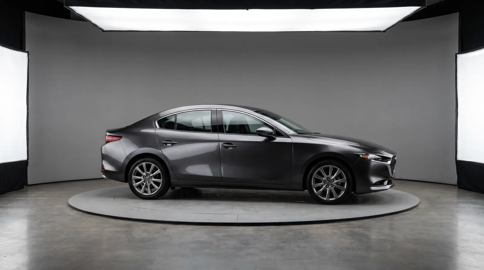 Sedan on a turntable platform in a professional automotive photo studio