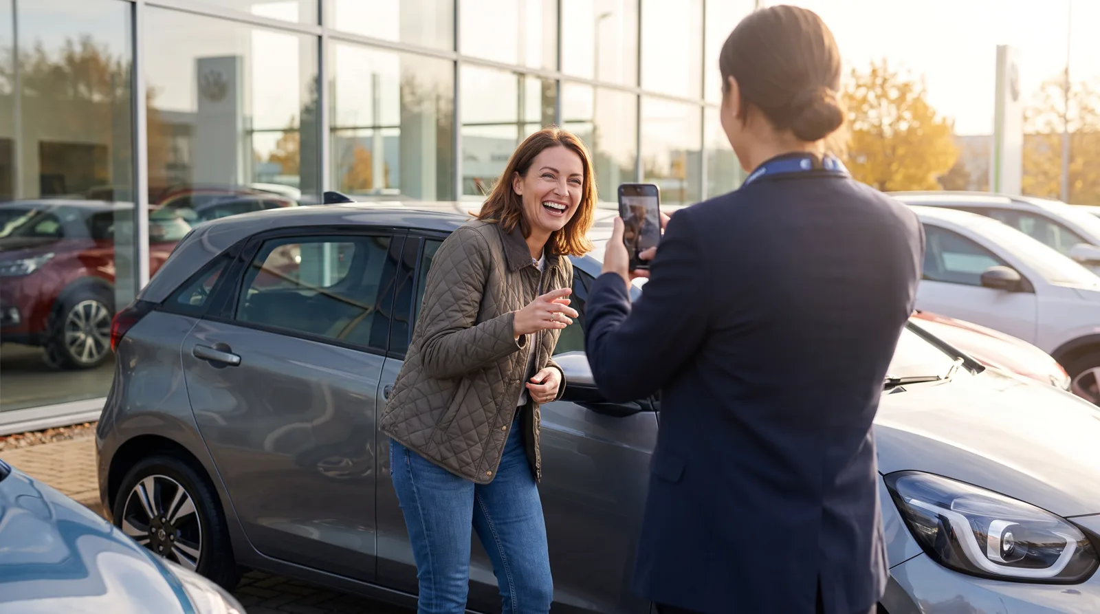 Happy customer beside their new car speaking to a smartphone camera at handover